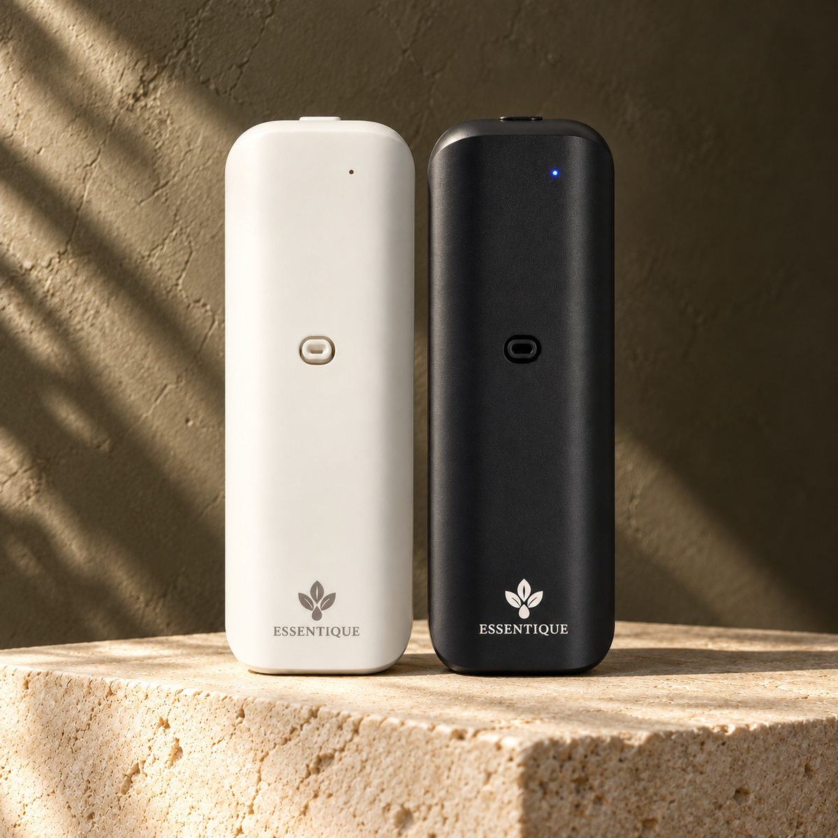White and black Essentique The Pulse diffusers standing side by side at matching height on limestone.